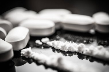 Close-up view of opioid pills and powdered fentanyl highlighting the critical issues related to drug overdose and prescription misuse in today's healthcare landscape. clipart