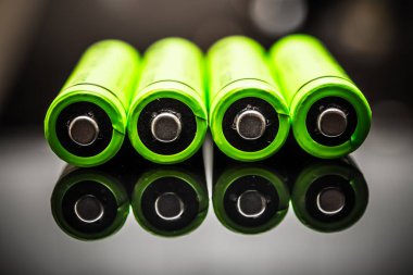 A close-up view of bright green AAA batteries showcasing advanced power cell technology, emphasizing renewable energy solutions for eco-friendly devices. clipart