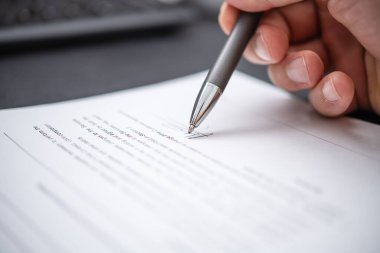 Bir bireyin çağdaş bir çalışma alanında profesyonellik, yasallık ve bağlılığın kilit temaları vurgulanarak, parlak bir kalemle gerekli belgeleri imzaladığı odaklanmış bir an..
