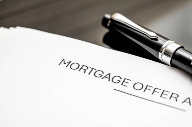 Önemli mali kararlar ve ev alıcıları ve emlak yatırımcıları için emlak yatırımlarını temsil eden parlak bir dolmakalemle eşleştirilmiş bir ipotek teklifinin ayrıntılı bir görünümü.