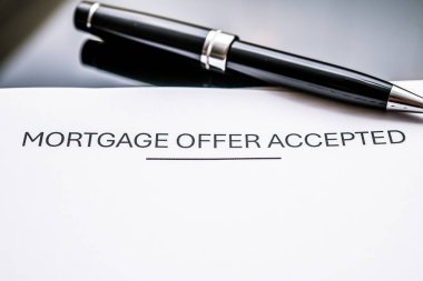 Ev satın alma, finansman, kredi anlaşmaları ve mülk satın almada hayati önem taşıyan 'kabul edildi' başlıklı bir ipotek mektubunun yakın çekimi. Müstakbel ev sahipleri ve gayrimenkul yatırımcıları için önemli.