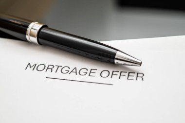 Mortgage, ev kredisi anlaşmaları, finansman seçenekleri ve potansiyel alıcılar ve ev sahipleri için gayrimenkul yatırım olanaklarını sembolize eden şık bir kalemle ilgili belge sunuyor.