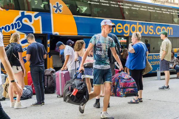 New York NY ABD-24 Temmuz 2016 Gezginleri, New York, Chelsea 'deki bir bütçe seyahati olan Megabus' tan bavullarını alıyorlar.