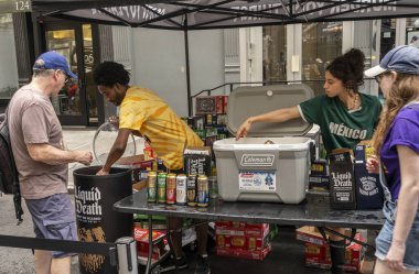 New York NY USA-July 13, 2024 Brand activation and free samples of Liquid Death water at a street fair The water is sold in cans similar to those you drink beer from clipart