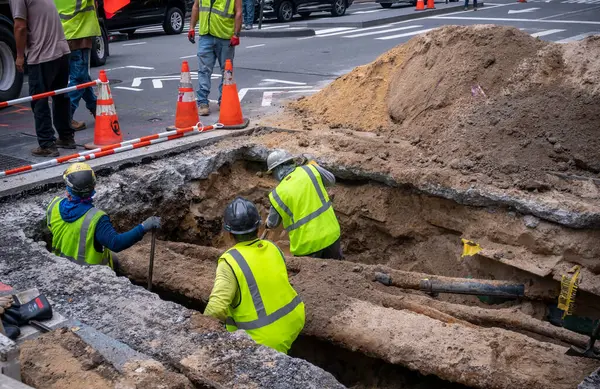 New York NY ABD-17 Ağustos 2024 İşçiler New York 'un Chelsea mahallesinde 9. Cadde' de bir çukur kazıyorlar. 