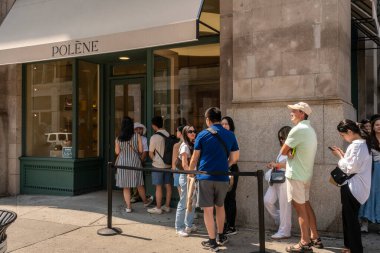 New York NY USA August 24, 2024 Line of shoppers waiting to enter the Polne Parisian leather goods store Soho in New York clipart