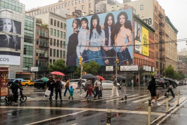 New York NY USA-September 28, 2024 Shoppers walk past a Calvin Klein billboard featuring the K-Pop girl group New Jeans in the Soho neighborhood of New York clipart