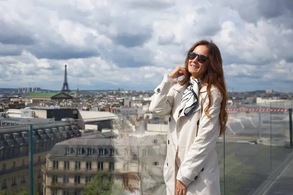 Şehrin ufuk çizgisine bakan bir Paris binasının çatısındaki kız. Yüksek kalite fotoğraf
