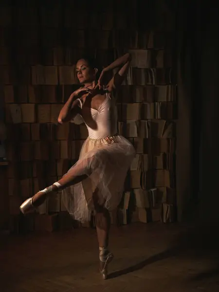 Kitaplığa karşı sivri uçlu ayakkabılı balerin. Bale pozları. Yüksek kalite fotoğraf