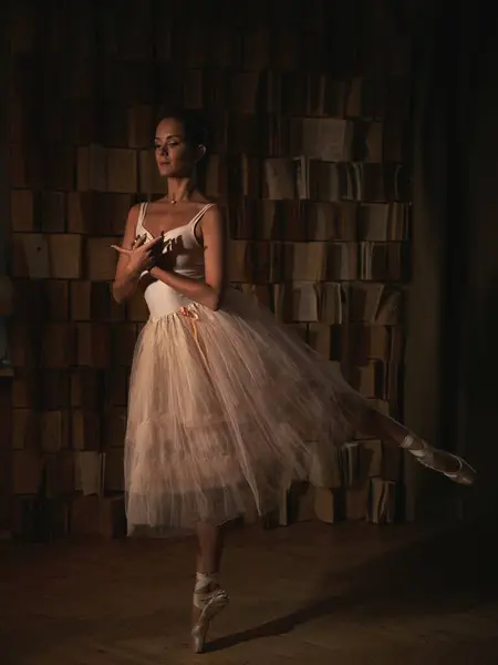 Kitaplığa karşı sivri uçlu ayakkabılı balerin. Bale pozları. Yüksek kalite fotoğraf