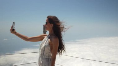 Kız bulutların üstünde selfie çekiyor. Yüksek kalite 4k görüntü