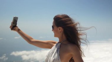 Kız bulutların üstünde selfie çekiyor. Yüksek kalite 4k görüntü