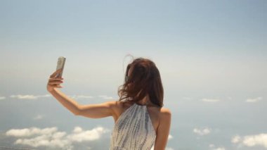 Kız bulutların üstünde selfie çekiyor. Yüksek kalite 4k görüntü