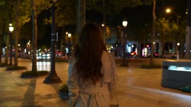 Paris, Fransa. Akşamları Champs-Elysees caddesi ve yürüyen bir kız. Yüksek kalite 4k görüntü