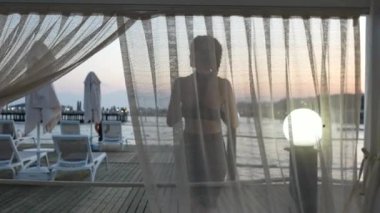 Akdeniz kıyısındaki bir terastan gün batımını izleyen bir kız. Yüksek kalite 4k görüntü