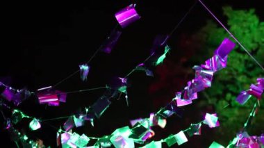 Açık havada farklı renklerde parıldayan renkli dekorasyonlar. Yüksek kalite 4k görüntü