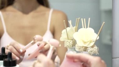 Kız, Gua Sha ve Roller 'ı aynanın önünde yüz bakımı için kullanıyor. Yüksek kalite 4k görüntü