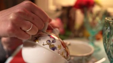 Eski bir kafeye eski tabakları kullanarak kaynar su döken bir kız. Yüksek kalite 4k görüntü