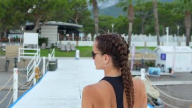 İskelede spor takım elbiseli bir kız yürüyor. Yüksek kalite 4k görüntü
