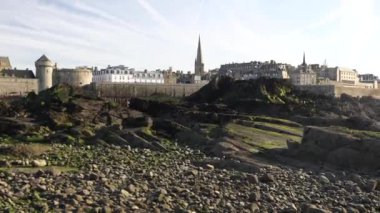 Saint-Malo, Fransa. Dalgalar alçaldığında sahilde yosun içinde kayalar. Yüksek kalite 4k görüntü