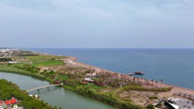 Belek 'teki nehrin üzerinden Türk kumlu plajına uçuyor. Yüksek kalite 4k görüntü