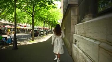 Beyaz önlüklü bir kız Paris sokaklarında yürüyor. Yüksek kalite 4k görüntü