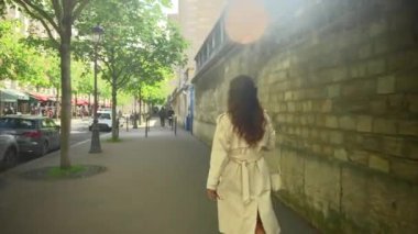 Beyaz önlüklü bir kız Paris sokaklarında yürüyor. Yüksek kalite 4k görüntü