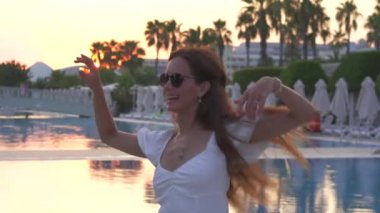 Havuz kenarında dans eden mutlu kız. Yüksek kalite 4k görüntü