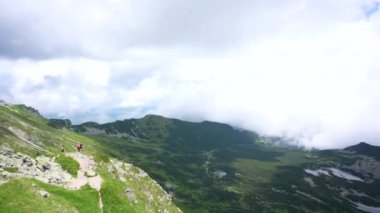 Üstte telefonu olan bir kız. Zakopane, bulutların sisinde panoramik manzara. Yüksek kalite 4k görüntü