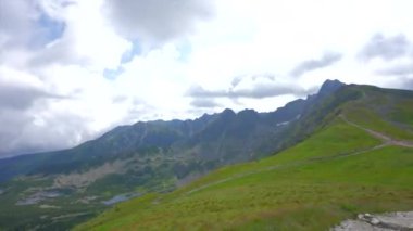 Üstte telefonu olan bir kız. Zakopane, bulutların sisinde panoramik manzara. Yüksek kalite 4k görüntü
