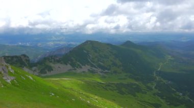 Üstte telefonu olan bir kız. Zakopane, bulutların sisinde panoramik manzara. Yüksek kalite 4k görüntü