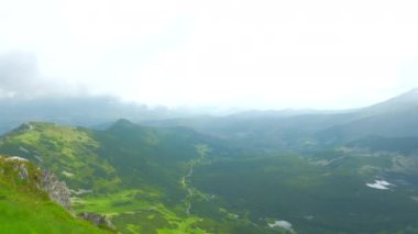 Üstte telefonu olan bir kız. Zakopane, bulutların sisinde panoramik manzara. Yüksek kalite 4k görüntü