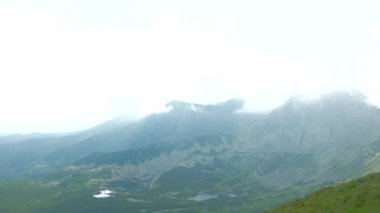 Üstte telefonu olan bir kız. Zakopane, bulutların sisinde panoramik manzara. Yüksek kalite 4k görüntü