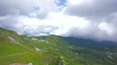 Üstte telefonu olan bir kız. Zakopane, bulutların sisinde panoramik manzara. Yüksek kalite 4k görüntü
