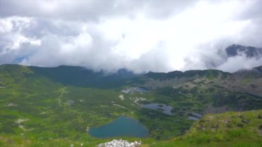 Üstte telefonu olan bir kız. Zakopane, bulutların sisinde panoramik manzara. Yüksek kalite 4k görüntü