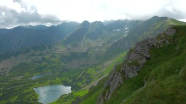 Üstte telefonu olan bir kız. Zakopane, bulutların sisinde panoramik manzara. Yüksek kalite 4k görüntü