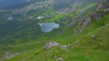 Üstte telefonu olan bir kız. Zakopane, bulutların sisinde panoramik manzara. Yüksek kalite 4k görüntü