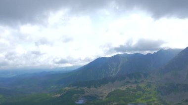 Üstte telefonu olan bir kız. Zakopane, bulutların sisinde panoramik manzara. Yüksek kalite 4k görüntü