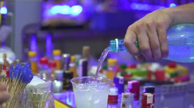 Bar tezgahındaki bir kokteylin içine tonik dökmek. Yüksek kalite 4k görüntü