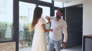 Neşeli bir çift, doğal ışıkla dolu, parlak ve modern bir iç mekanda, keyifli bir dansı mutlulukla paylaşıyor.