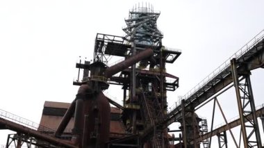 Terk edilmiş bir sanayi bölgesinin paslı yapıları, yaşlanma teknolojisinin ve zengin tarihin etkilerini açıkça yansıtıyor.