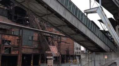 Kalabalık bir şehir ortamındaki harap olmuş endüstriyel yapıların ve boruların büyüleyici ve çarpıcı görüntüsü