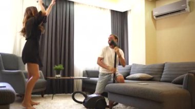 Bir çift birlikte evi temizler, gülümseme ve kahkahalarla işin tadını çıkarırlar. Onların eğlenceli etkileşimleri, neşeli bir ortaklığı yansıtan eğlenceli, neşeli bir aktiviteye dönüştürür.