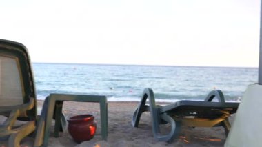 Antalya 'nın dingin güzelliğini, kristal berrak sulara karşı kurulmuş plaj şezlonglarıyla deneyin. Seyahat, turizm ve lüks kaçamaklar ve deniz kenarı kaçamakları gösteren yaşam tarzı projeleri için mükemmel. 4k 