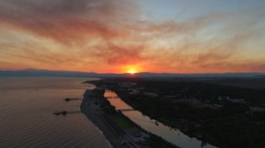 Günbatımı nehri sıcak renklerde boyar ve bir tekne huzur içinde yüzer. Yukarıdan çekilen sakin sahne, teknenin sakin suları keserek gün batımının parıltısını yansıtıyor.