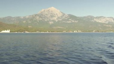 Hareket eden yat, açık sakin denizin ve engebeli kayaların nefes kesici manzarasını gözler önüne seriyor. Yumuşak dalgalar ve parlak güneş, suda rahatlamak ve macera yaşamak için mükemmel sakin bir atmosfer yaratır.