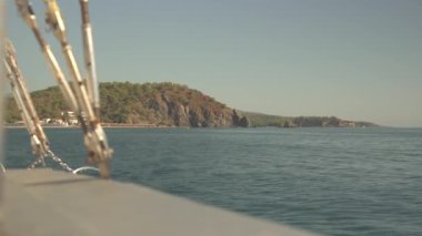 Hareket halindeki bir yatın güvertesinden berrak ve sakin denizin huzurlu manzarasının tadını çıkarın. Huzurlu su durmaksızın uzanıyor ve yat okyanus yüzeyinde sorunsuz bir şekilde süzülürken huzur hissi yaratıyor.