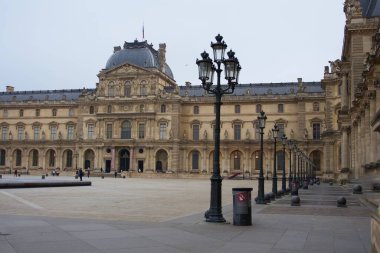 Louvre Müzesi avlusunda klasik Fransız mimarisinin zarif, modern cam piramitle uyumlu bir karışımı sergileniyor.. 