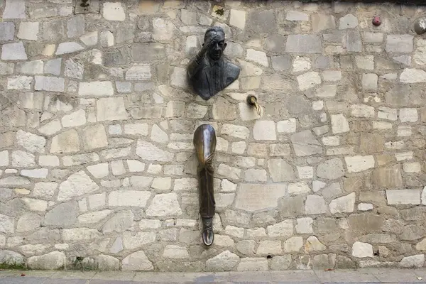 Marcel Aymes 'in hikayesinden ünlü bir karakter olan Le Passe-Muraille' nin eşsiz heykeli Montmartre, Paris 'teki taş bir duvardan ortaya çıkmış gibi görünüyor. Yüksek kalite fotoğraf