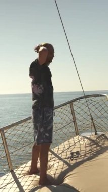 Genç bir adam bir geminin pruvasında duruyor ve etrafındaki doğal güzelliklere bakıyor. Bu huzurlu an, onun okyanuslara ve çevresine olan minnettarlığını yansıtıyor.